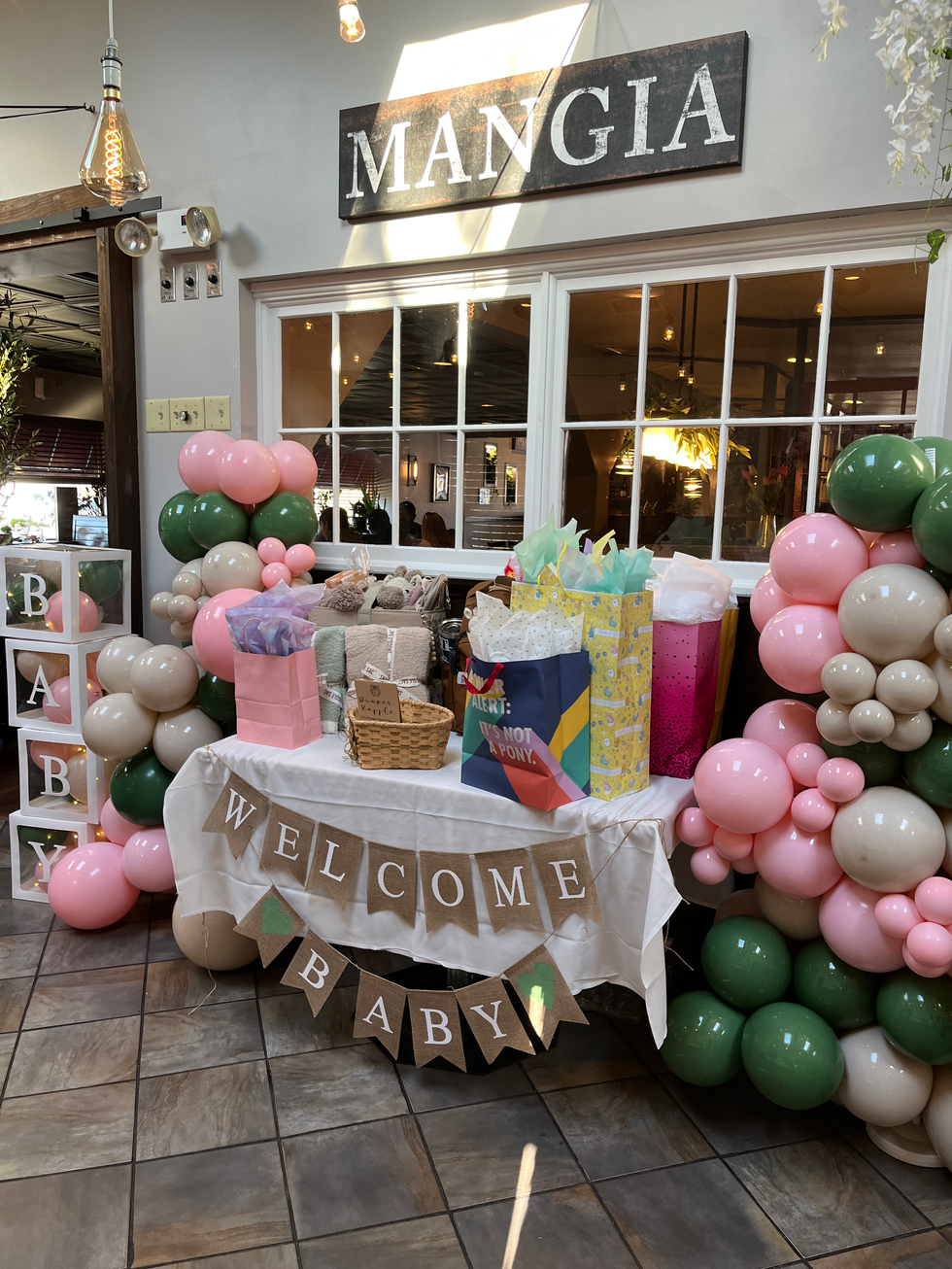 Baby shower with gifts, balloons, and "WELCOME BABY" banner