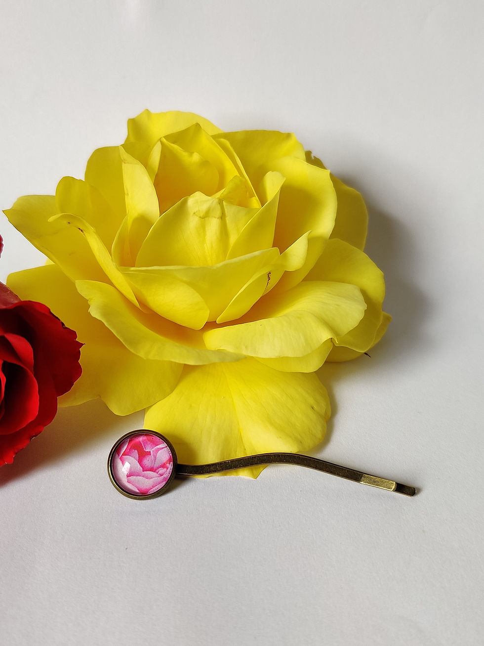 Thumbnail: Botanical-inspired resin hairpin with floral print encased in a round cabochon setting