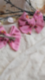 a set of pink pigtail bows with multicolour floral embroidery