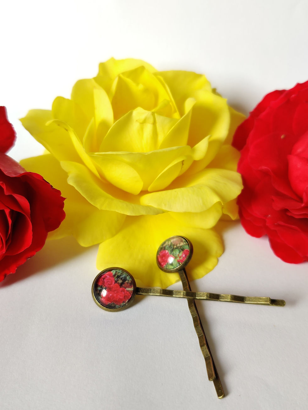 Thumbnail: Botanical-inspired resin hairpin with floral print encased in a round cabochon setting