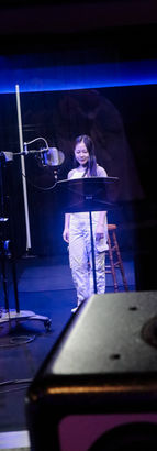 Voice actor recording a bilingual commercial voiceover demo with professional direction