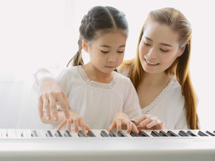 電子ピアノを使って個別レッスンを受ける子どもと講師の様子。