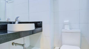 acomodacoes um vaso sanitário branco ao lado de uma pia em um banheiro. HOTEL DOMANI