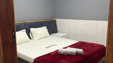 acomodacoes uma cama com cobertor vermelho e travesseiros brancos. HOTEL FLERT SANTANA