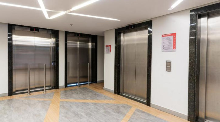 acomodacoes uma fileira de elevadores dentro de um prédio. HOTEL MEGA POLO