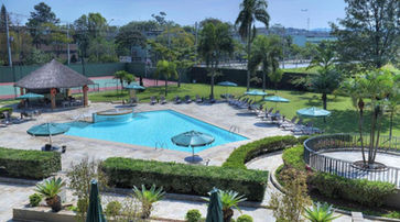 entretenimento vista aérea de uma grande piscina com espreguiçadeiras e guarda-sóis. MARRIOTT SÃO PAULO AIRPORT HOTEL
