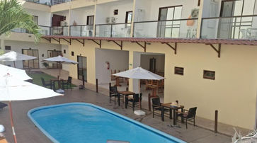 acomodacoes uma piscina rodeada por mobiliário e guarda-sóis. POUSADA CANTO DOS CORAIS