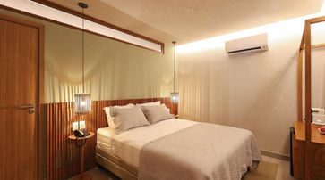acomodacoes um quarto de hotel com cama, mesinhas de cabeceira e espelho. AMARAÍZ POUSADA.