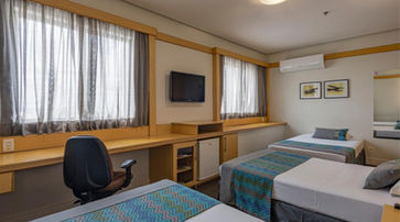acomodacoes um quarto de hotel com três camas e uma escrivaninha. MONREALE PLUS GUARULHOS INTERNATIONAL AIRPORT