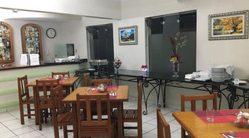 gastronomia uma sala de jantar repleta de mesas e cadeiras de madeira. IPÊ GUARU HOTEL