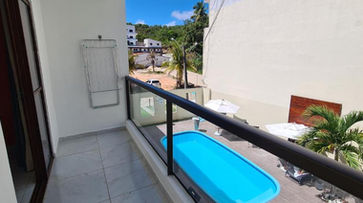 acomodacoes vista de uma piscina a partir de uma varanda. POUSADA CANTO DOS CORAIS