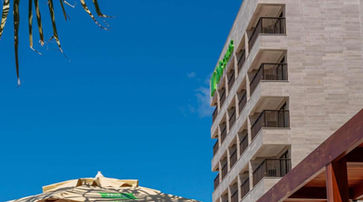 entretenimento um edifício alto com varandas ao lado de um guarda-chuva