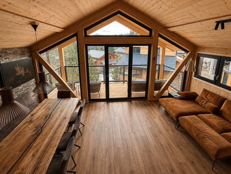 Wohnbereich und Esstisch mit Balkon und Bergblick im Chalet Cembra