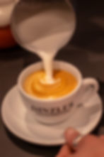 KONRADs Kaffeespezialitäten Latte Art aufgeschäumte Milch wird dem Kaffee hinzugegeben