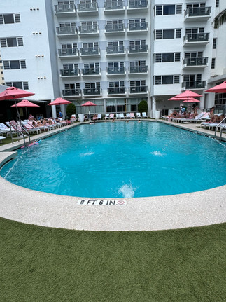  Outdoor pool area at the Cadillac Hotel Miami Beach with pink umbrellas and ocean-inspired design — a highlight of the Autograph Collection experience.