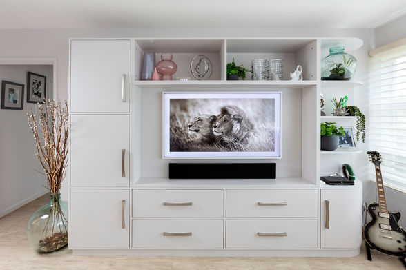 Lounge interior design in grade 2 listed apartment in Richmond. Shows grey sofa, footstool and artwork. Green leather tub chair, Grey media unit and Gibson guitar on a guitar stand. Richmond interior design.