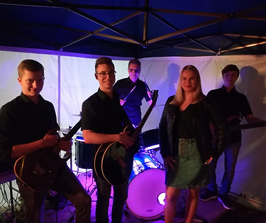 Bandmitgliedier mit Instrumenten nach Auftritt mit Ambientebeleuchtung