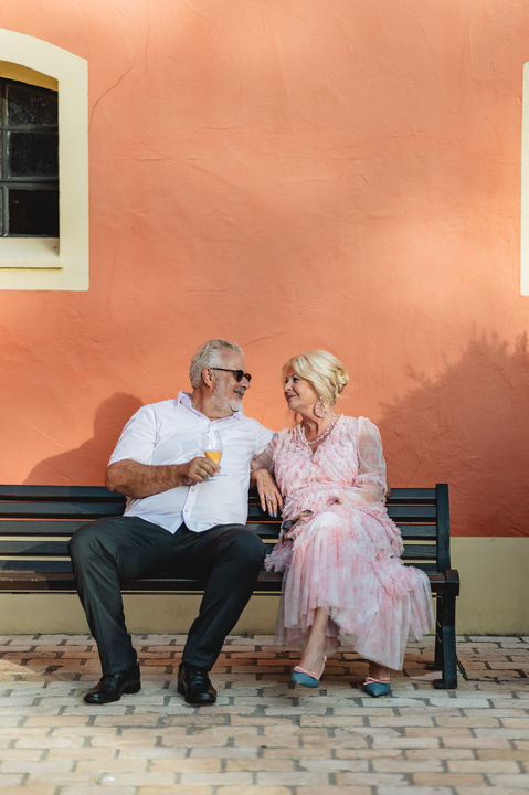 Wedding guests seated on benches during Esther and Nico’s outdoor reception in Luxembourg, photographed by wedding photographer Jérôme Neumann.
