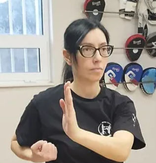 Background φωτογραφία από ιδιαίτερο μάθημα αυτοάμυνας στο Applied Wing Tzun, όπου μία γυναίκα εκπαιδεύεται σε τεχνικές αντίδρασης και ελέγχου, με πλήρη καθοδήγηση εκπαιδευτή. Τα ιδιαίτερα μαθήματα προσφέρουν εξατομικευμένη προπόνηση, προσωπικό ρυθμό μάθησης, προσαρμογή στις ανάγκες του ασκούμενου και άμεση, πρακτική βελτίωση των δεξιοτήτων αυτοάμυνας. Διαθέσιμα στο Χαλάνδρι & την Αγία Παρασκευή. (Wing Tzun – γνωστό και ως Wing Chun)