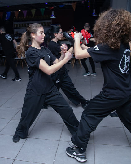 Background φωτογραφία από το εφηβικό τμήμα του Applied Wing Tzun, όπου έφηβοι εξασκούνται σε χτυπήματα σε pads μέσα σε καθοδηγούμενο και ασφαλές περιβάλλον προπόνησης. Η άσκηση ενισχύει δύναμη, συντονισμό, αυτοπεποίθηση και σωστή εφαρμογή τεχνικών αυτοάμυνας — στοιχεία που βοηθούν τους εφήβους να αναπτύξουν σωματική και ψυχική ισορροπία. Τμήματα Χαλανδρίου & Αγίας Παρασκευής. (Wing Tzun – γνωστό και ως Wing Chun)