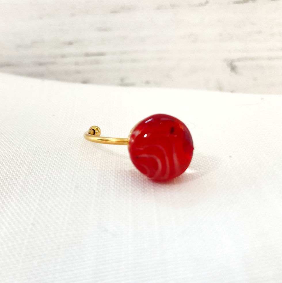 Thumbnail: Alternate view of Glass fused ring set on an adjustable gold band. Glass stone made of shade of opaque white, and reds.
