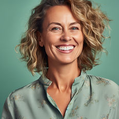 Lächelnde Frau mit blonden lockigen Haaren älter als 40