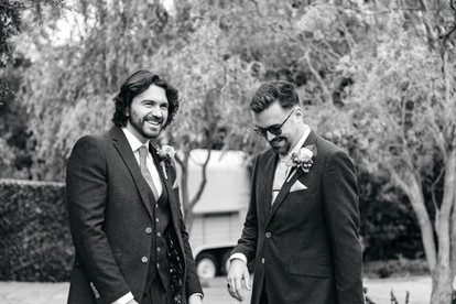 Groom and best man laughing at East Mersea Hall wedding