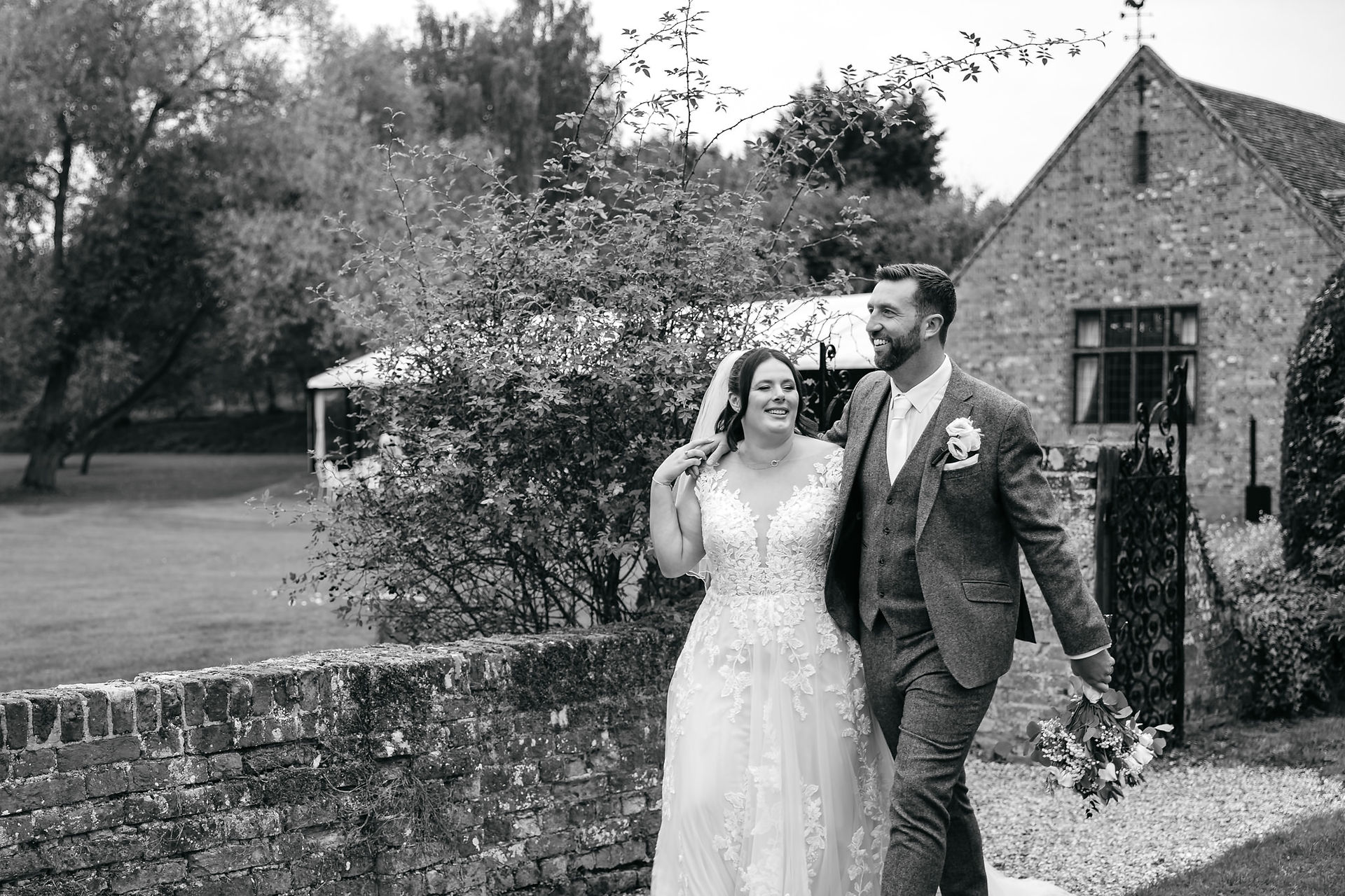 Bride and groom walking arm in arm Seckford Hall wedding 