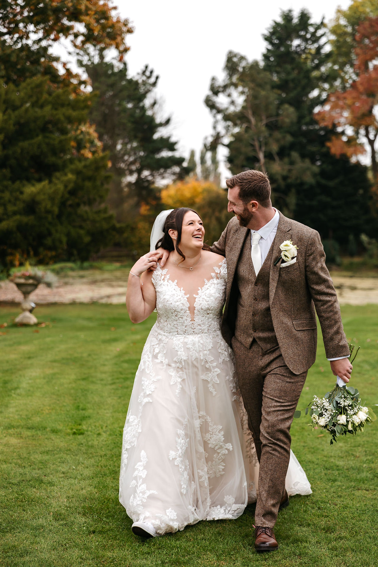 Bride and groom walking arm in arm Seckford Hall wedding 