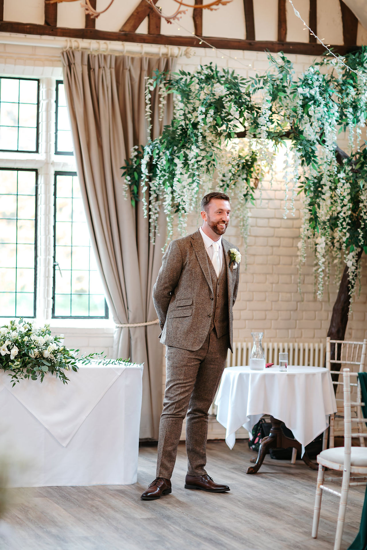 Groom waiting at end of aisle at Seckford Hall wedding 