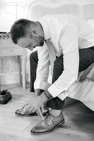 Groom putting on shoes at High House Wedding, Maldon