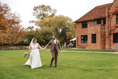 Bride and groom walking around venue Seckford Hall wedding