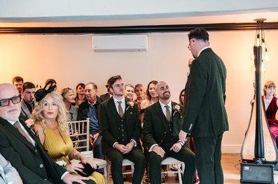 Groom talking to groomsmen before ceremony at East Mersea Hall wedding