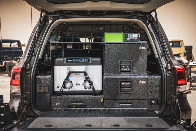 Rear of a 200 Series with fridge, dual RV Storage Solutions drawers, and power panel in custom touring layout.