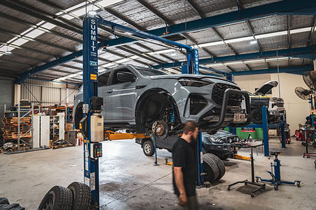 Isuzu MU-X on workshop hoist during Lovells GVM upgrade installation to 3325kg at BAW Automotive Brisbane.
