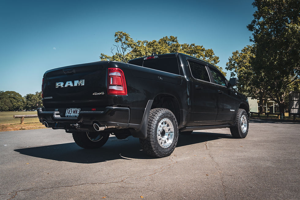 Black RAM 1500 Laramie 4x4 rear three-quarter view, fitted with a Brown Davis long range fuel tank for towing.