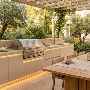Luxury outdoor kitchen design with built-in BBQ, stone worktop and alfresco dining table
