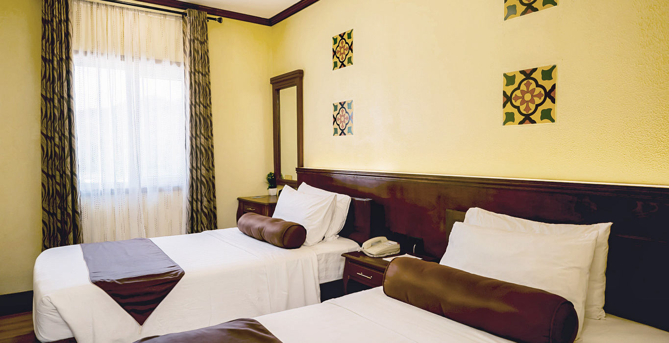 Two single beds against a wall in the Standard Room in Sunlight Hotel Coron