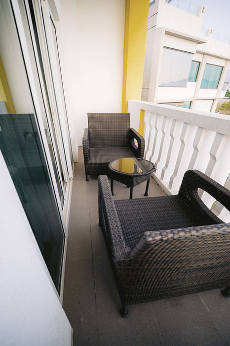 Balcony of Deluxe Room Ocean View with two lounge chairs and a coffee table with the view of the Coron Bay
