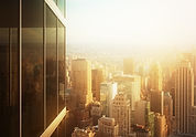 Cityscape reflected in the glass of an office building at sunset_edited.jpg