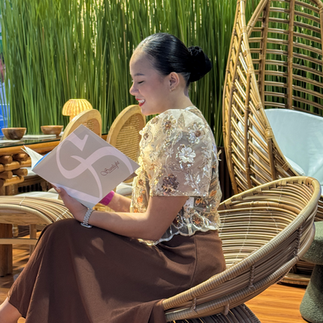 Photo of a woman reading a pamphlet while seated on the Serpyente Chair