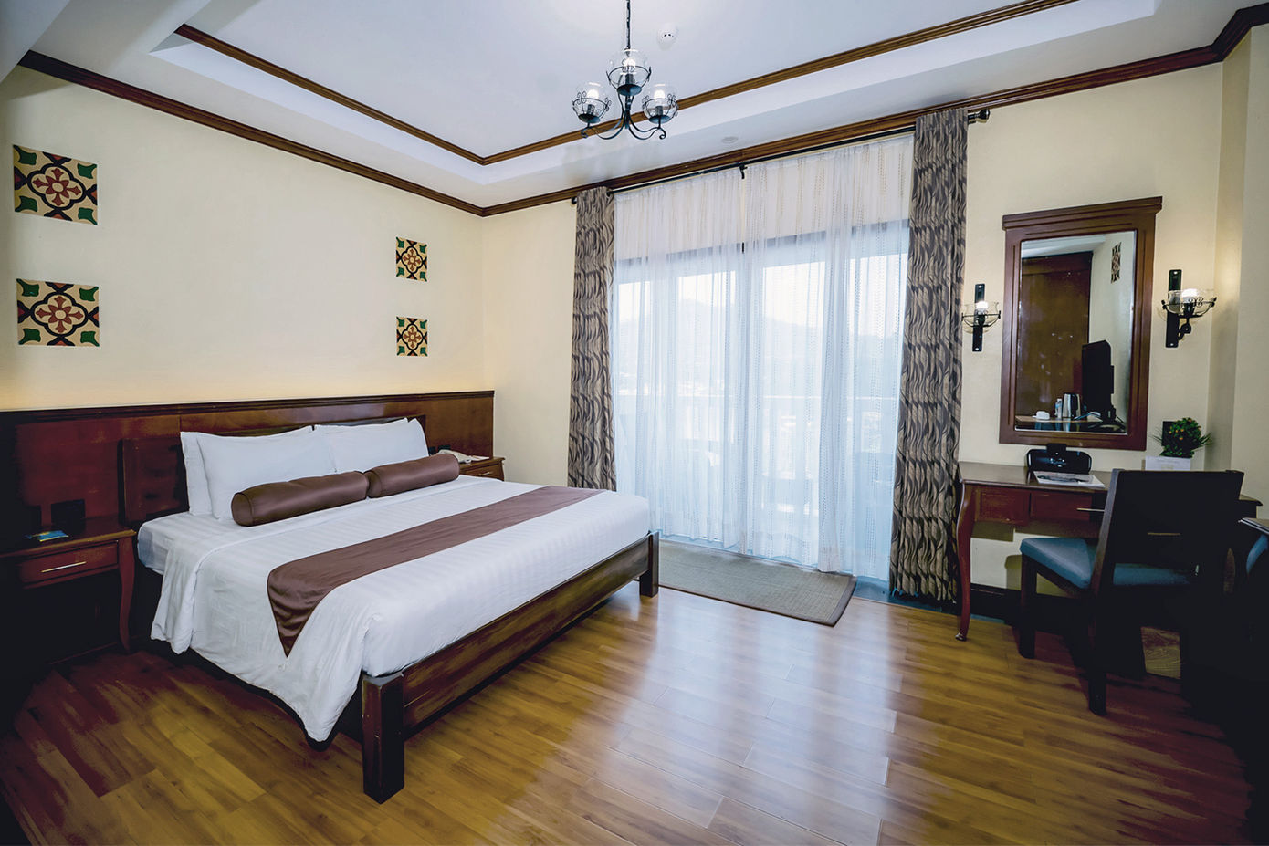 King sized bed against the wall with the Superior Room amenities and ocean view balcony