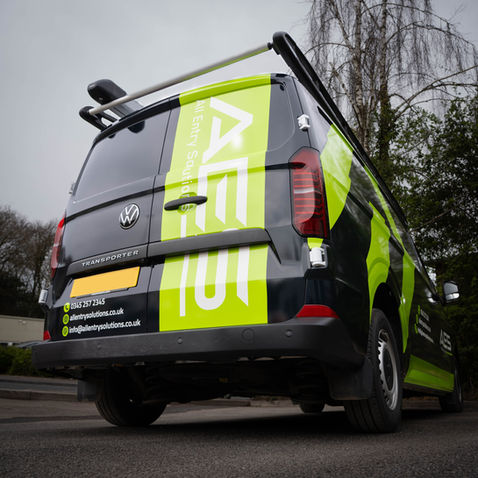 Van with green and black branding, parked outdoors.
