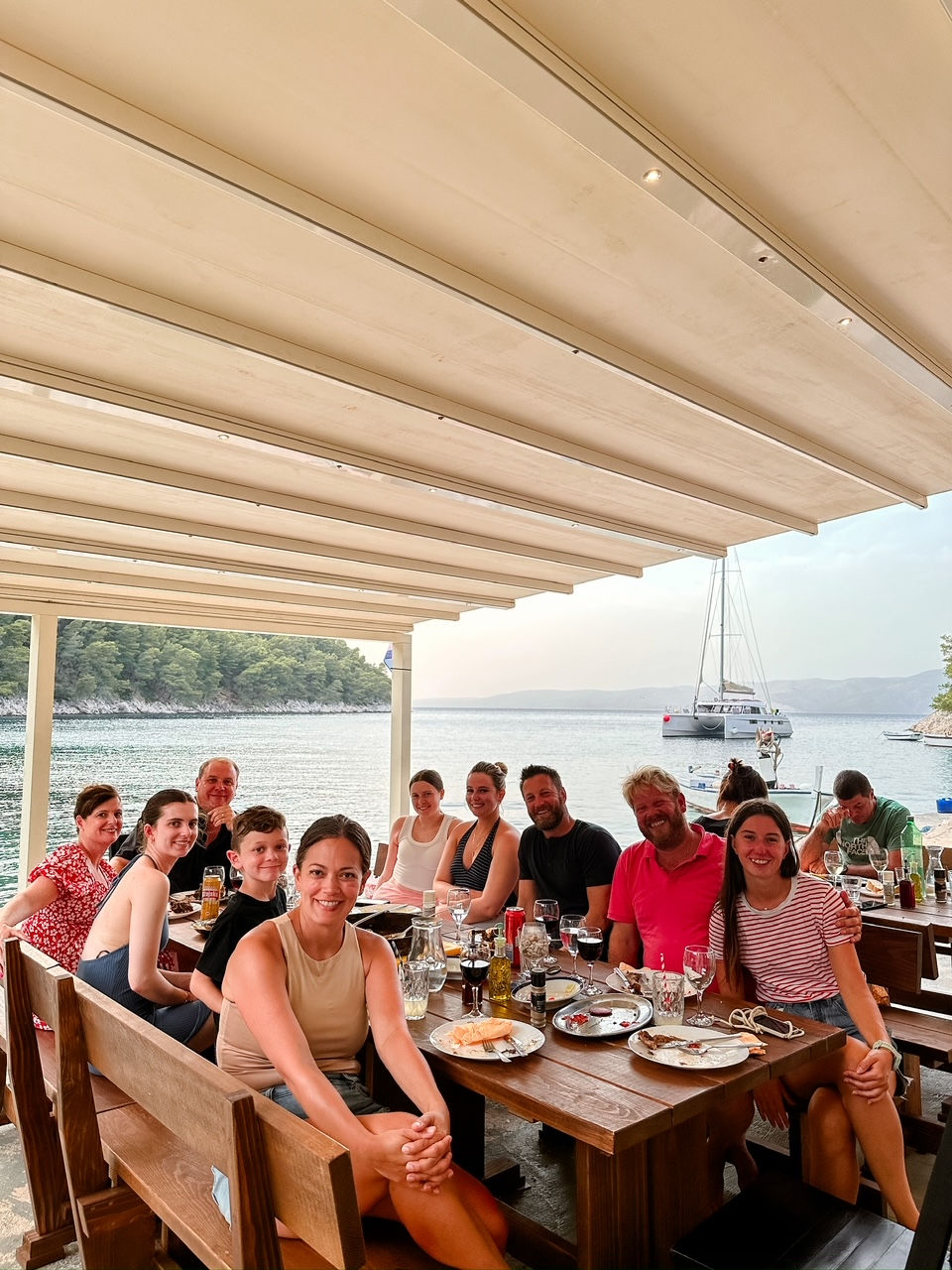 group of people having lunch outside next to water in croatia