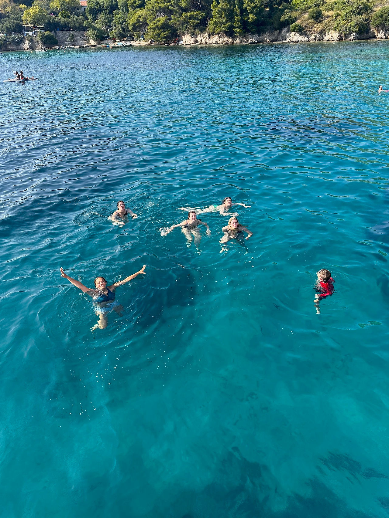 people swimming next to catamaran in croatia