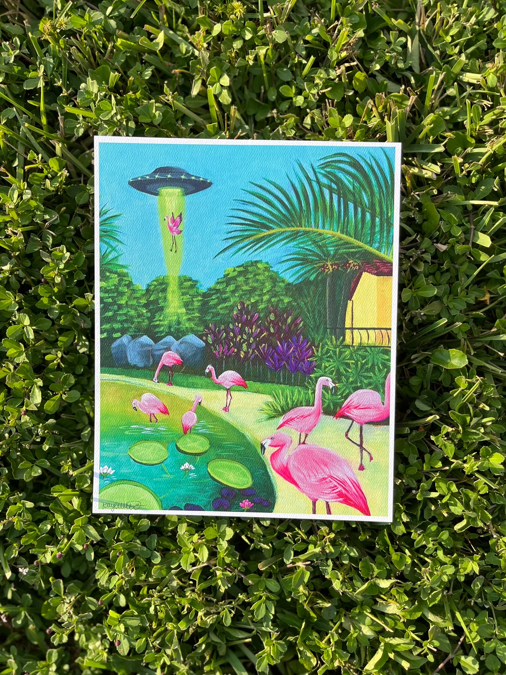 Bright pink flamingos and UFO abduction over a pond in tropical landscape by Kayla Heintz