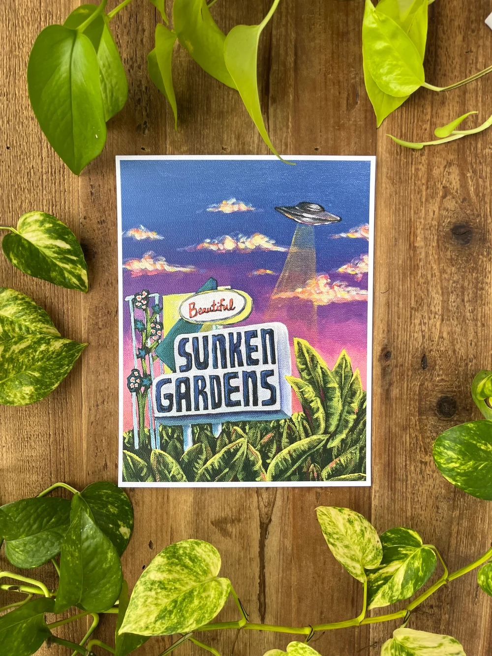 UFO above vintage Sunken Gardens sign surrounded by lush greenery by Kayla Heintz