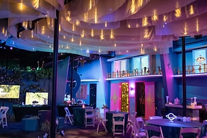 Wedding reception setup at FloridaRAMA featuring string lights, colorful décor, and immersive art surroundings.