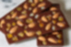 54% Dark Chocolate Bar with Whole Roasted Almonds, Candied Orange and Golden Raisins.