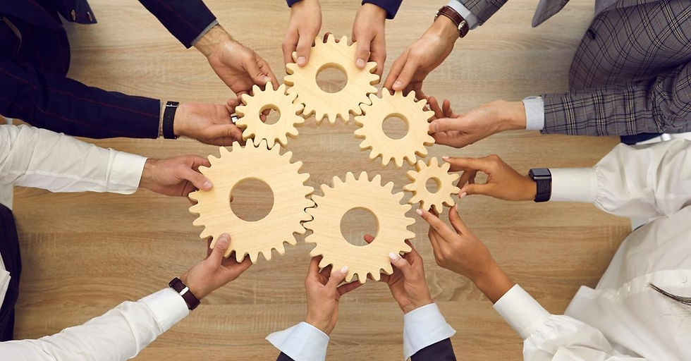 Hands holding six wooden cogs to resemble teamwork.